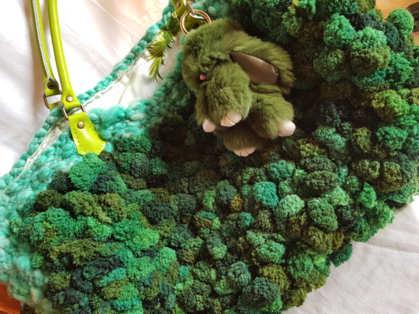 etalle del bolso de lana bucle, combinación de tonalidades verdes, forrado con tela de loneta y detalle de conejo piel sintética, asas de color verde de piel.