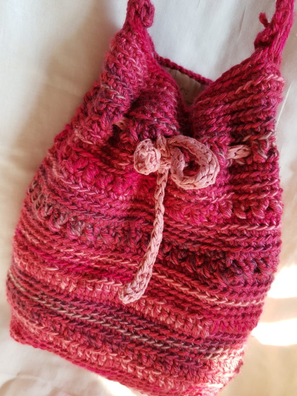 Detalle de la bolsa de crochet de colores fucsia combinado, forrada con tela de loneta