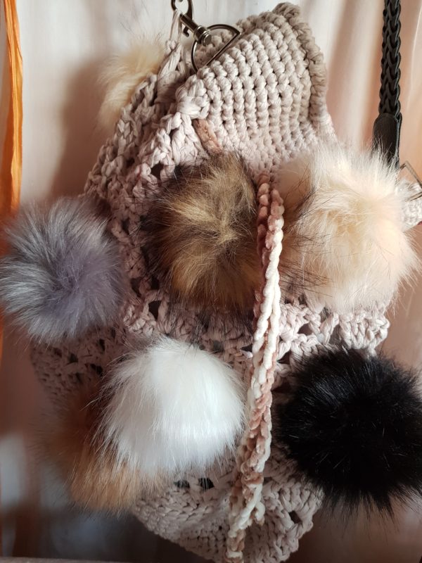 Detalle de la bolsa grande de crochet con hilo de algodon, forrada con tela dd loneta y 10 pompones de colores naturales con asa de terciopelo